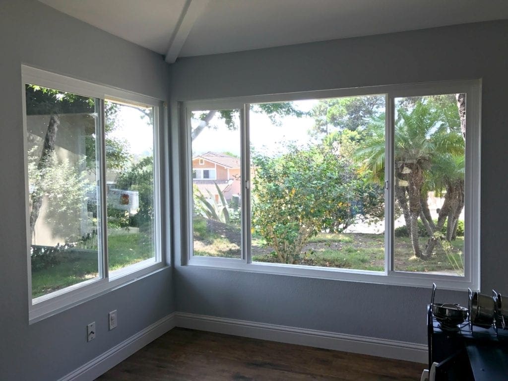 Before and after photos of our window replacement home improvement project. Not a DIY job for us but worth every penny of the cost. We went with vinyl windows instead of wood, and replaced the slider and screen instead of putting in french doors. Read the five biggest lessons we learned. #homeimprovement #diyproject #windows #interiordesign #investment #homedecor #beforeandafter 